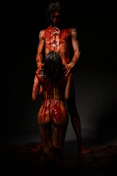 Sangrienta pareja desnuda vista contra la pared negra — Foto de Stock
