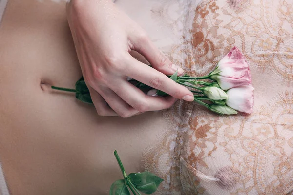 Vista cortada de mulher molhada em renda roupa interior segurando flores — Fotografia de Stock