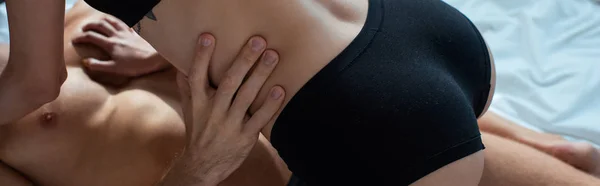 Панорамный снимок женщины в черных трусиках рядом с сексуальным мужчиной — стоковое фото